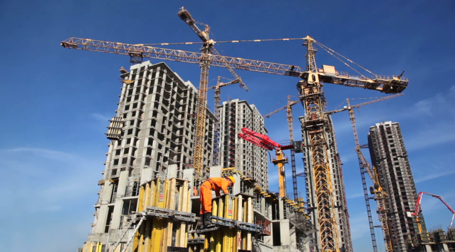 builder-works-at-against-background-of-the-construction-site-high-rise-buildings_qymk0vokd__F0000
